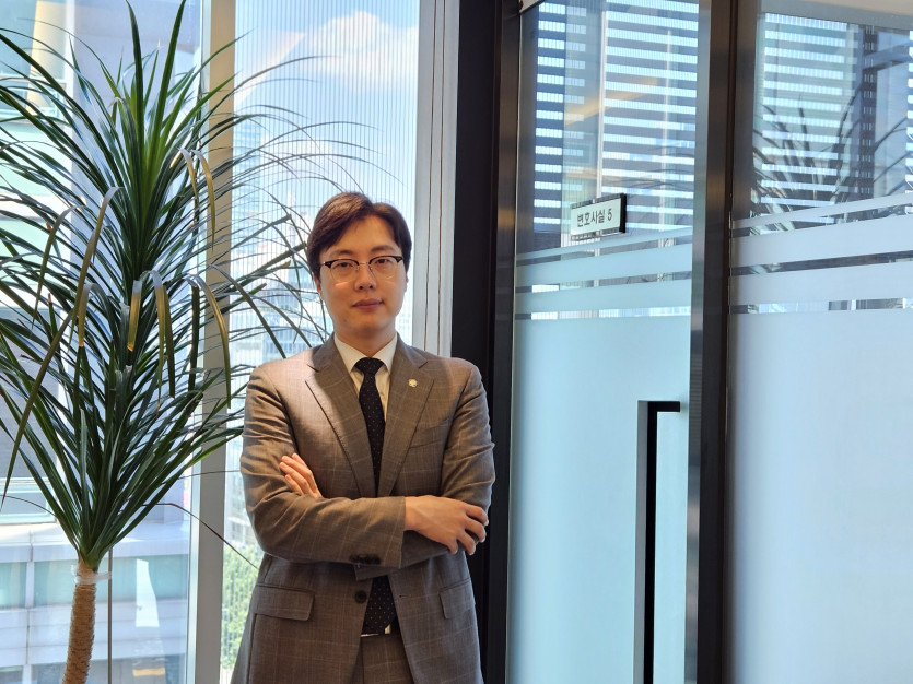 상담실 앞에 서서 팔짱을 끼고 서있는 이세환변호사
